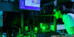 Engineer monitoring a laser setup with BeamTrack and StarLab software for beam pointing stability measurement